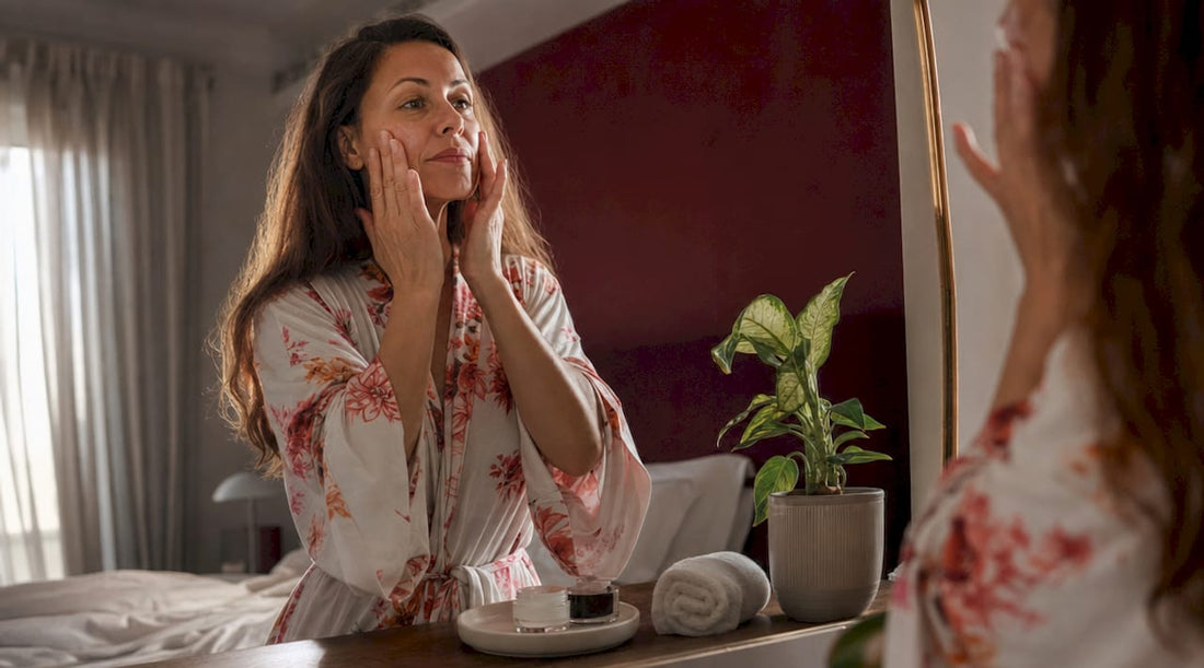 Mature woman applying moisturizer at vanity