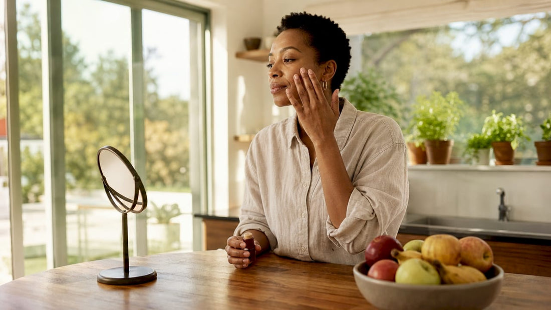 Woman applying multi-use makeup stick at vanity