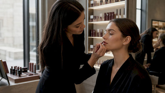 Makeup artist applying lip liner on lips
