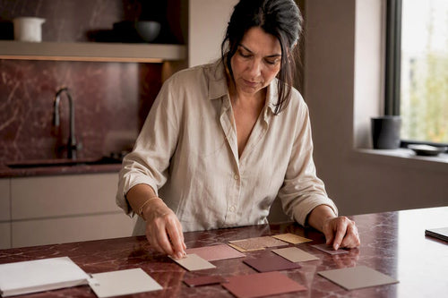 Hands arranging beauty swatches on velvet surface