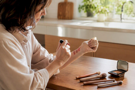 Woman swatching lipstick on wrist in natural light