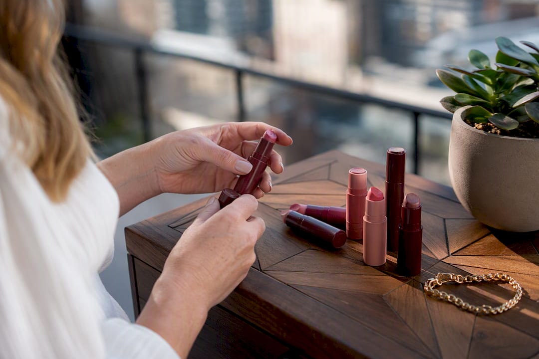 Hands organizing multi-use makeup on vanity
