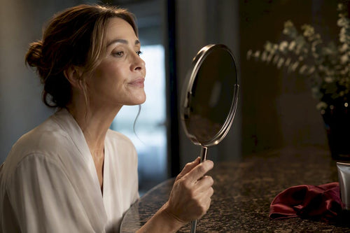 Mature woman checking lips in mirror