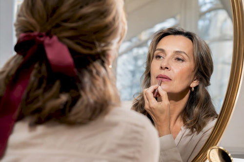 Woman testing rosewood lip color in daylight