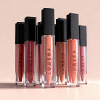 Luméra lip glosses on a beige background